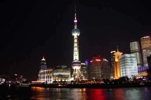 View of the Pearl Tower and surrounding buildings on the Shanghai river cruise at night.